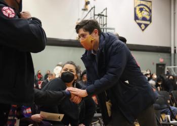 Men in Masks shaking hands at a funeral 